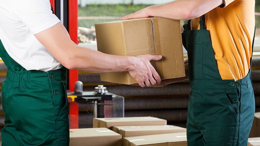 A men passing a box to another worker