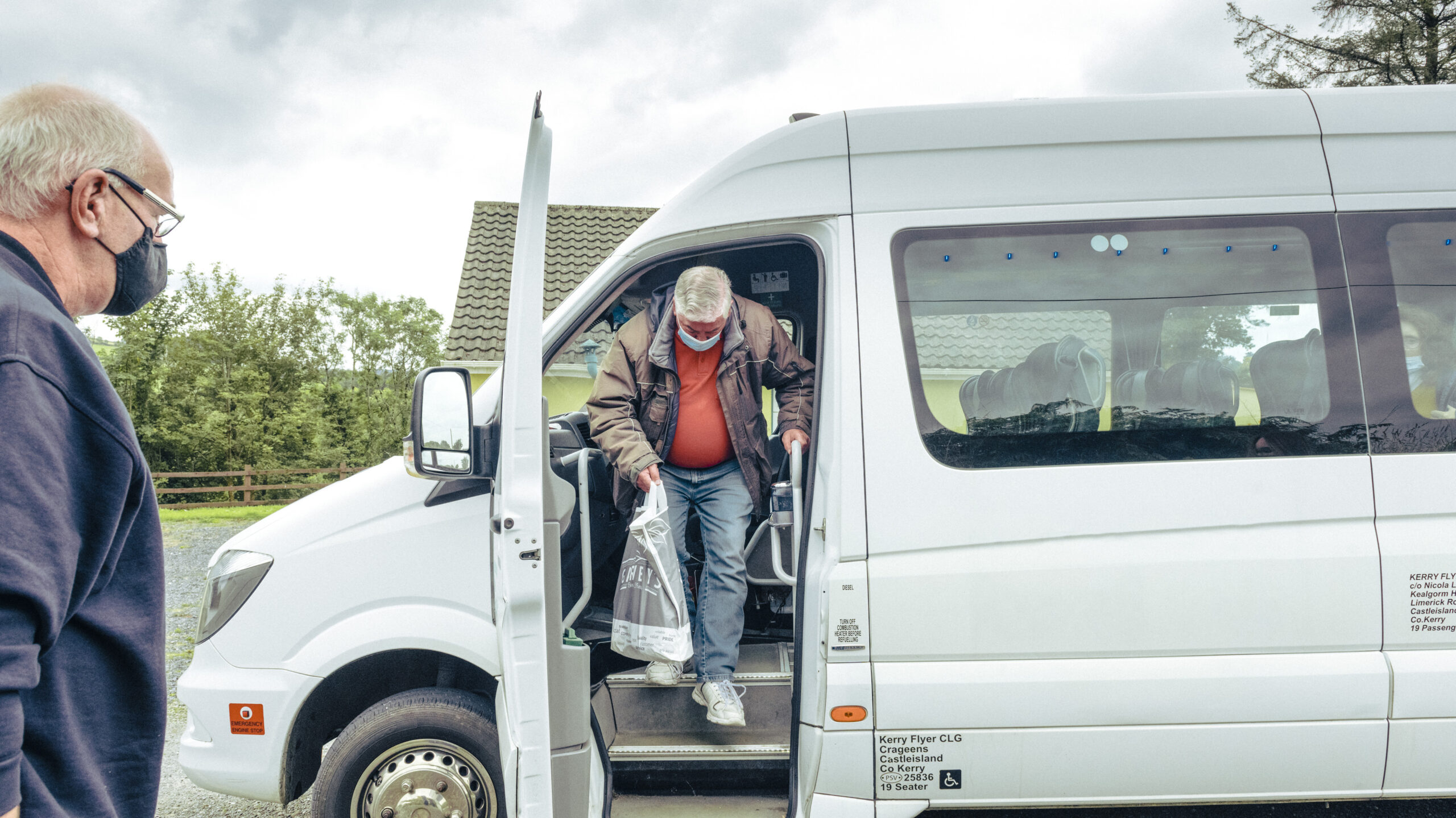 Bus driver assisting a passenger off the bus